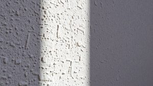 Texturi detaliate pe un perete, cu umbre subtile.